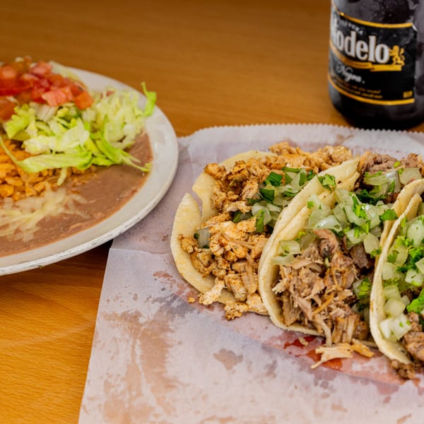 Three Sr. Tequila Mexican Grill tacos with a side of rice, beans, and a Modelo beer.